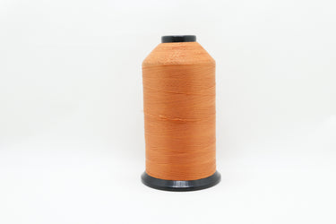 lubricated polyester thread made from pre-stabilised high tenacity continuous filament polyester in burnt orange shown up close