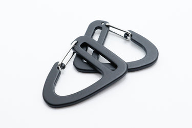 Two gray carabiner clips on a white background made out of aluminum