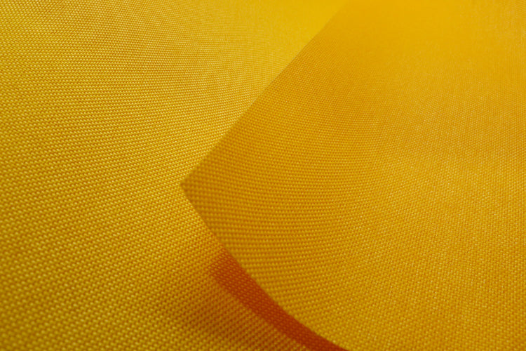 Close-up of gold colored Cordura Classic 1000D nylon 6.6 fabric texture