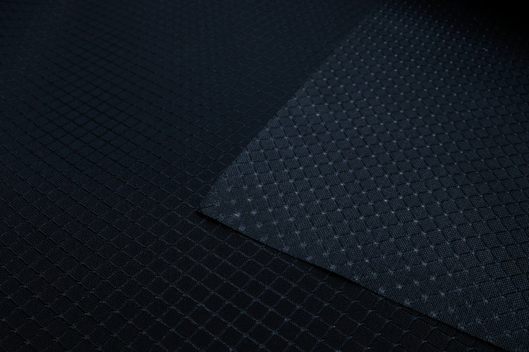 close-up of front and back of black diamond ripstop nylon fabric