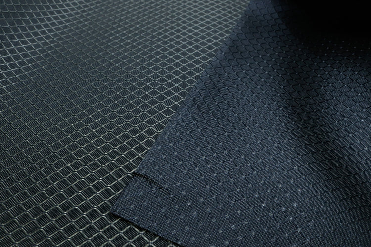 close-up of front and back of light grey diamond ripstop nylon fabric