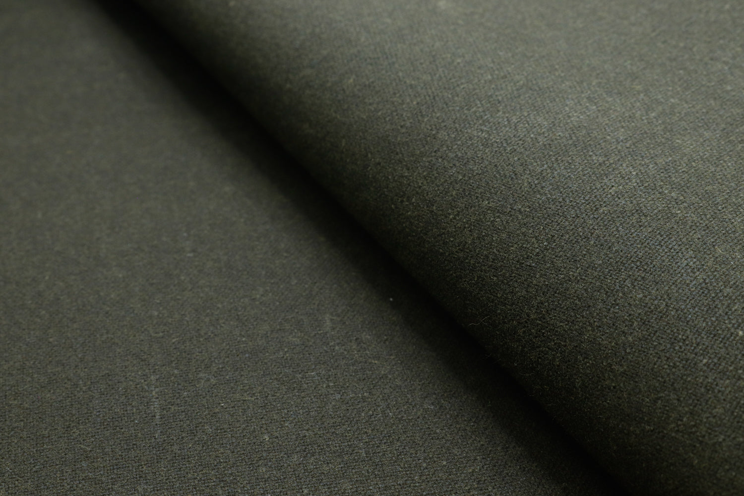 Close-up of waxed cotton canvas finish, highlighting the wax coating that repels water.