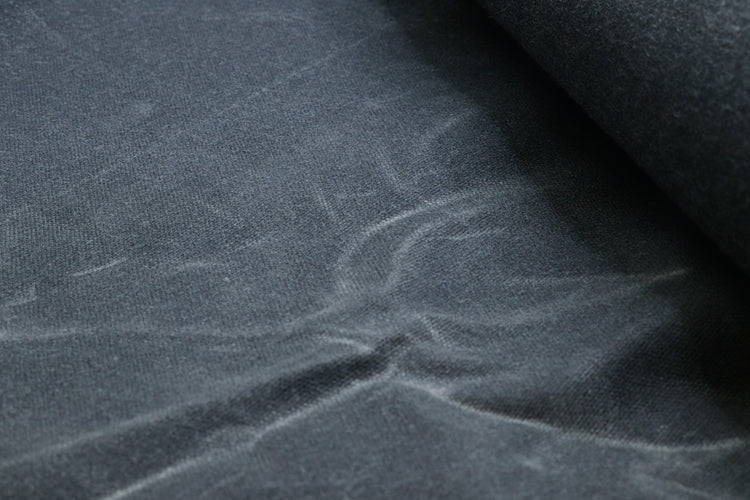 Close-up of waxed army duck canvas showing the dense weave and waxed coating for durability and water resistance.