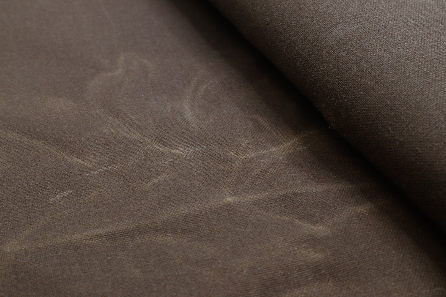 Close-up of waxed canvas showing natural creases and texture, perfect for handcrafted gear with character.