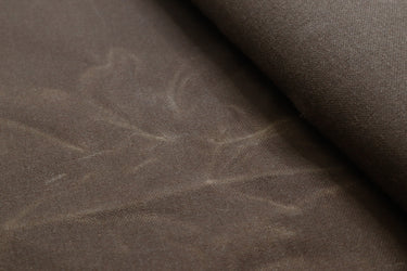 Close-up of waxed canvas showing natural creases and texture, perfect for handcrafted gear with character.