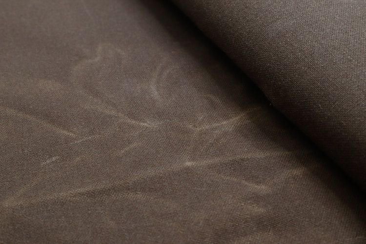 Close-up of waxed canvas showing natural creases and texture, perfect for handcrafted gear with character.