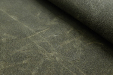 Close-up of waxed canvas showing natural creases and texture, perfect for handcrafted gear with character.