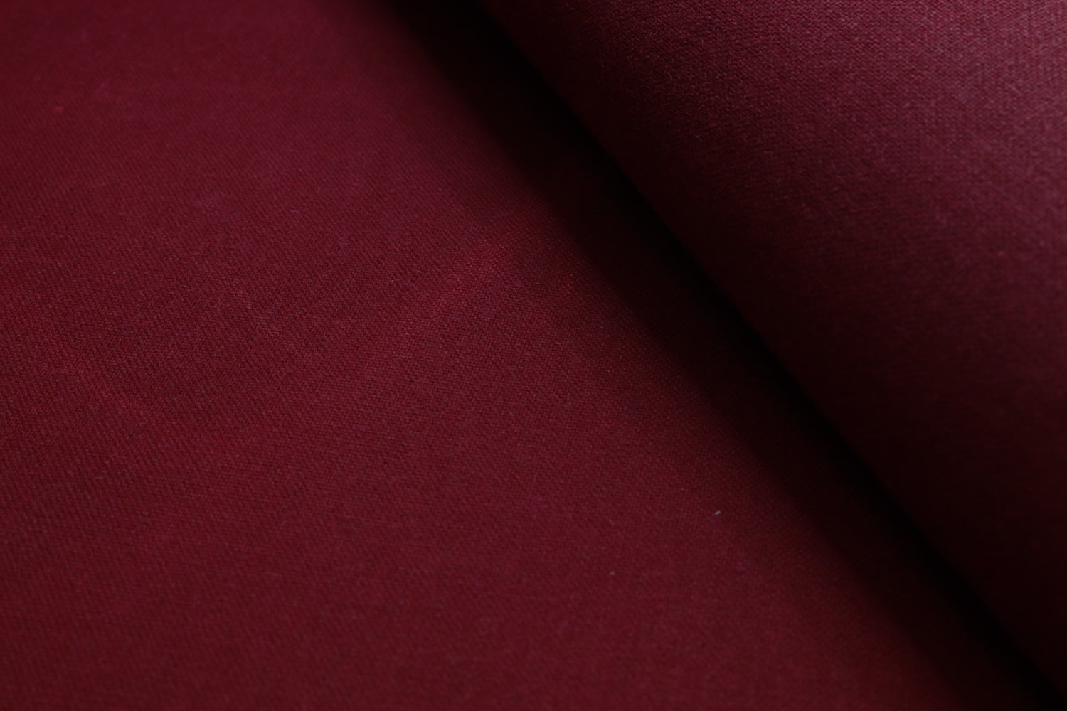 Close-up of waxed pink cotton canvas highlighting the subtle texture and light creases from the waxed finish.