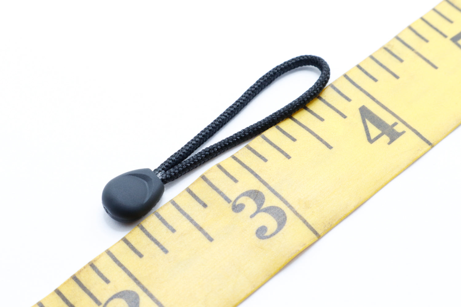 Tiny puller zipper pull/zipper grab next to sewing ruler
