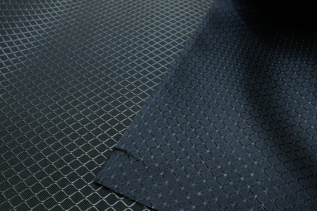 close-up of front and back of light grey diamond ripstop nylon fabric