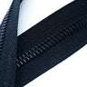 Close-up of black YKK metal zipper teeth and slider, highlighting the durable construction.