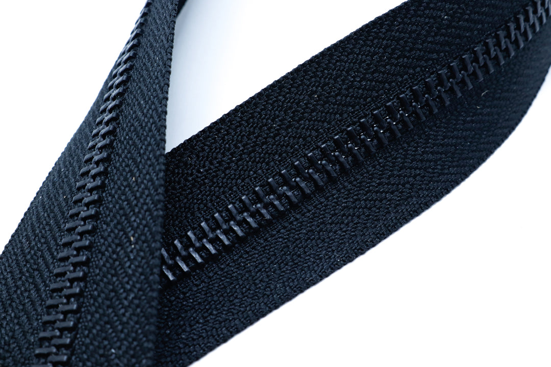 Close-up of black YKK metal zipper teeth and slider, highlighting the durable construction.