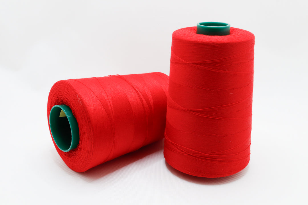 two 6000 yard spools of thread on a white background