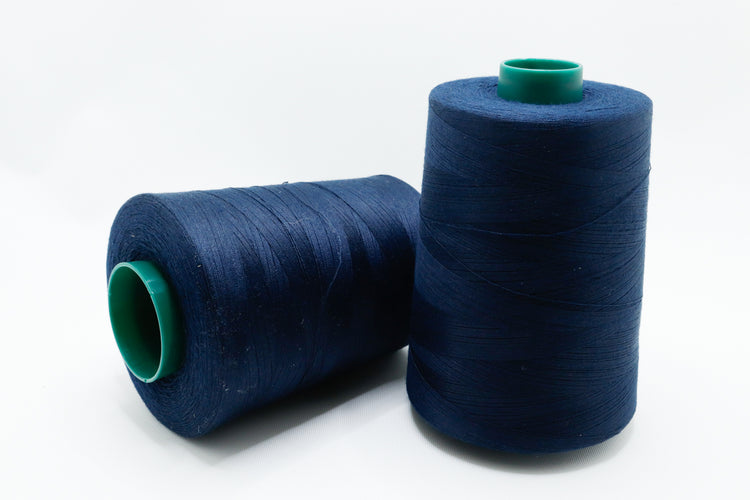 Two spools of blue thread on a white background