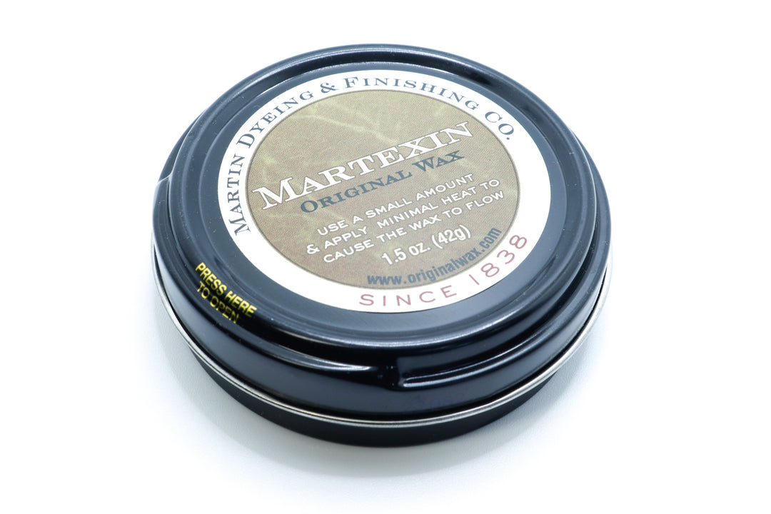 A tin of refinishing wax for waxed canvas fabrics