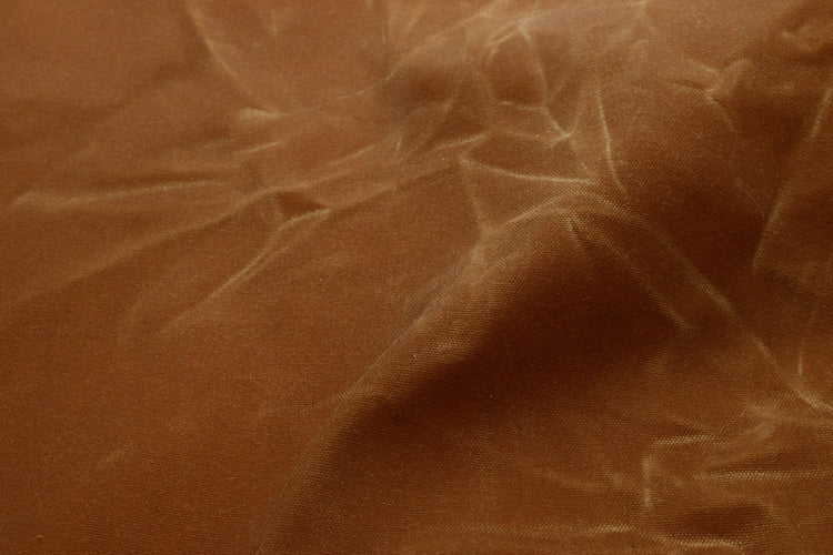 close up of a brown waxed canvas showing the crinkled texture