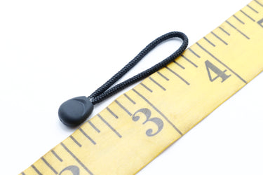 Tiny puller zipper pull/zipper grab next to sewing ruler