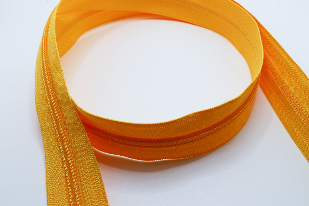 Yellow YKK #5 coil zipper chain on a white background